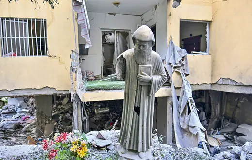 Figura św. Szarbela, maronickiego duchownego, mnicha i pustelnika, przed zniszczonym w izraelskim ataku budynkiem mieszkalnym w zamieszkanym głównie przez chrześcijan mieście Ain Saadeh nieopodal Bejrutu, 6 kwietnia 2026 r.